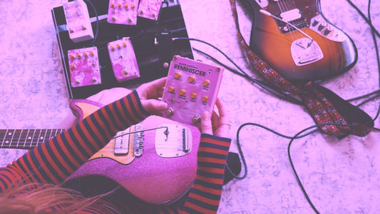 Paige of Dream Pop band Abstract in Sound holding the Reminiscer reverb pedal in front of pedalboard
