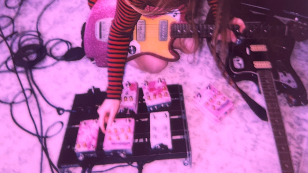 guitarists playing guitar pedals on a pedalboard 