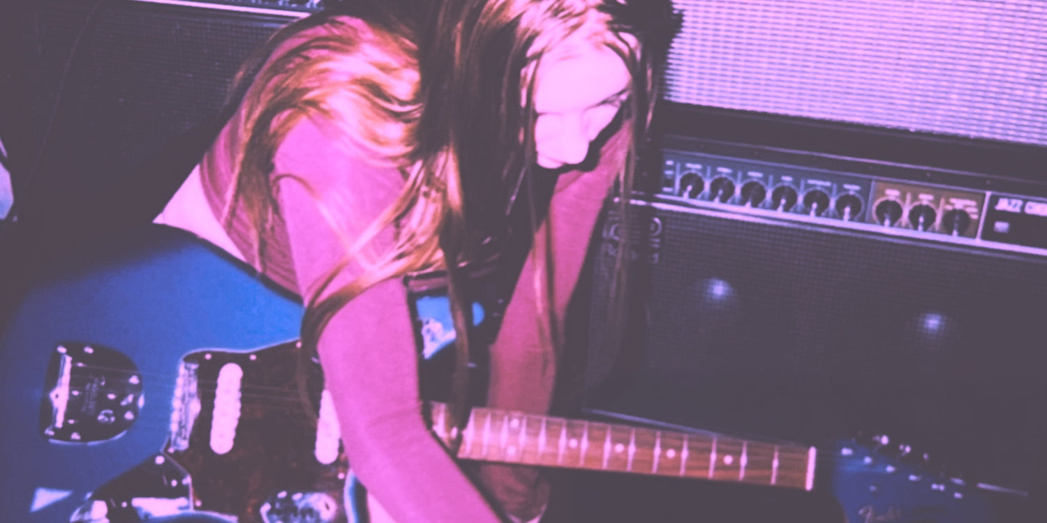 guitarist playing shoegaze guitar pedals in front of guitar amps while recording shoegaze music