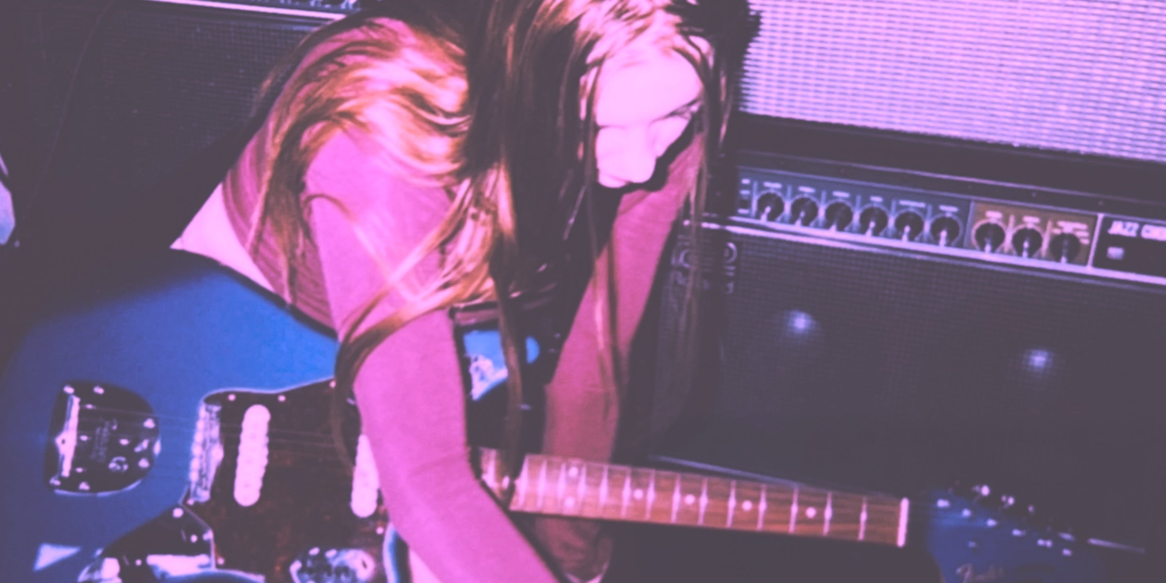 guitarist playing shoegaze guitar pedals in front of guitar amps while recording shoegaze music
