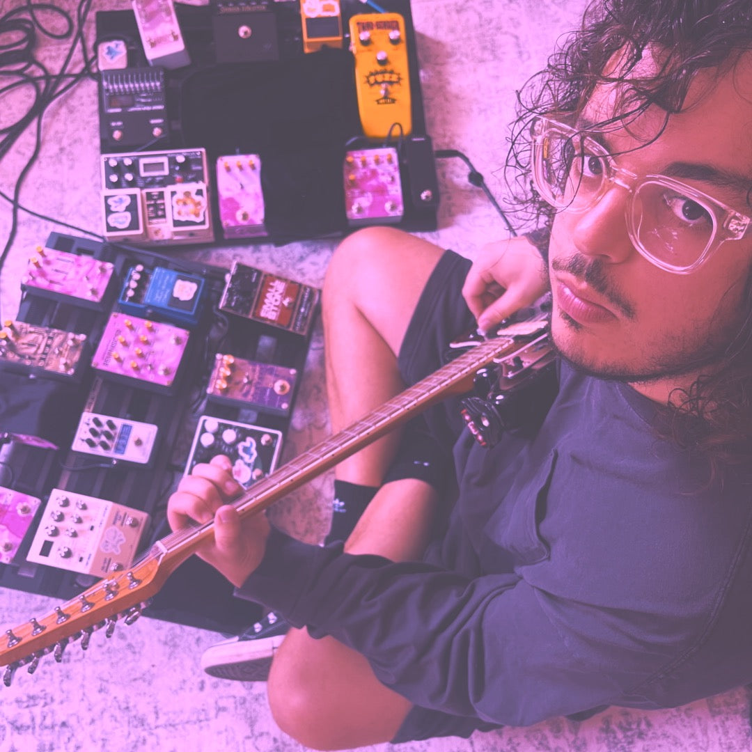 violet oscillation band playing shoegaze guitar surrounded by guitar pedals